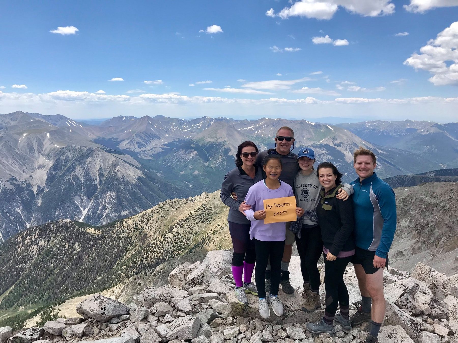 The Downs family together on the summit of Mount Princeton holding a Mount Princeton sign